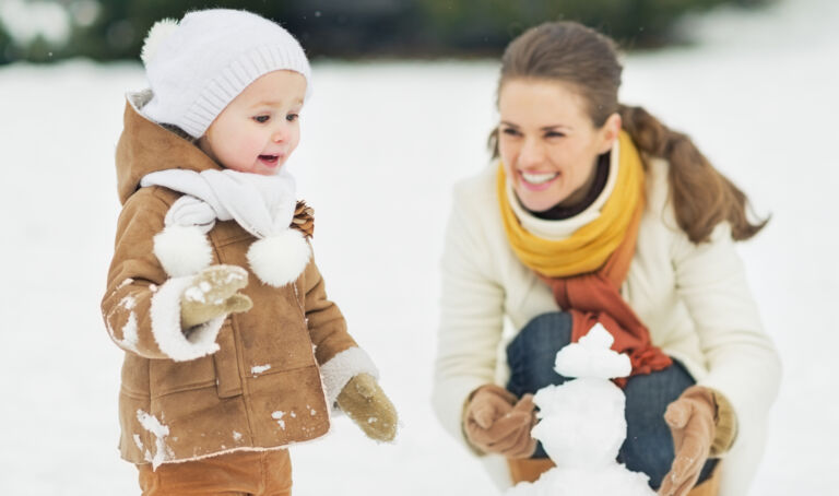 Mother and baby playing in snow